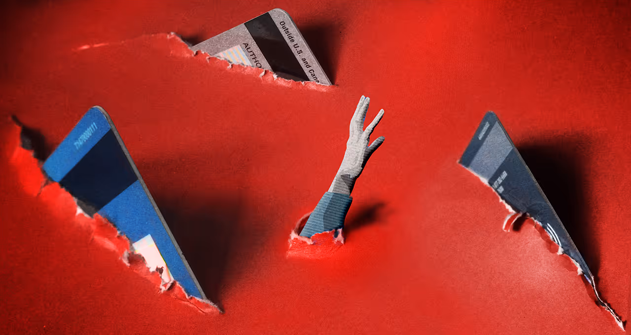 Editorial illustration of credit card shark fins circling hand reaching out from a paper sea of red